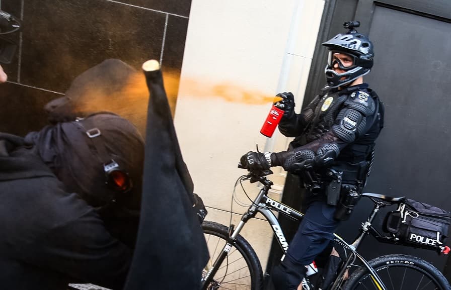 Un agente utiliza gas pimienta contra un manifestante en Seattle.