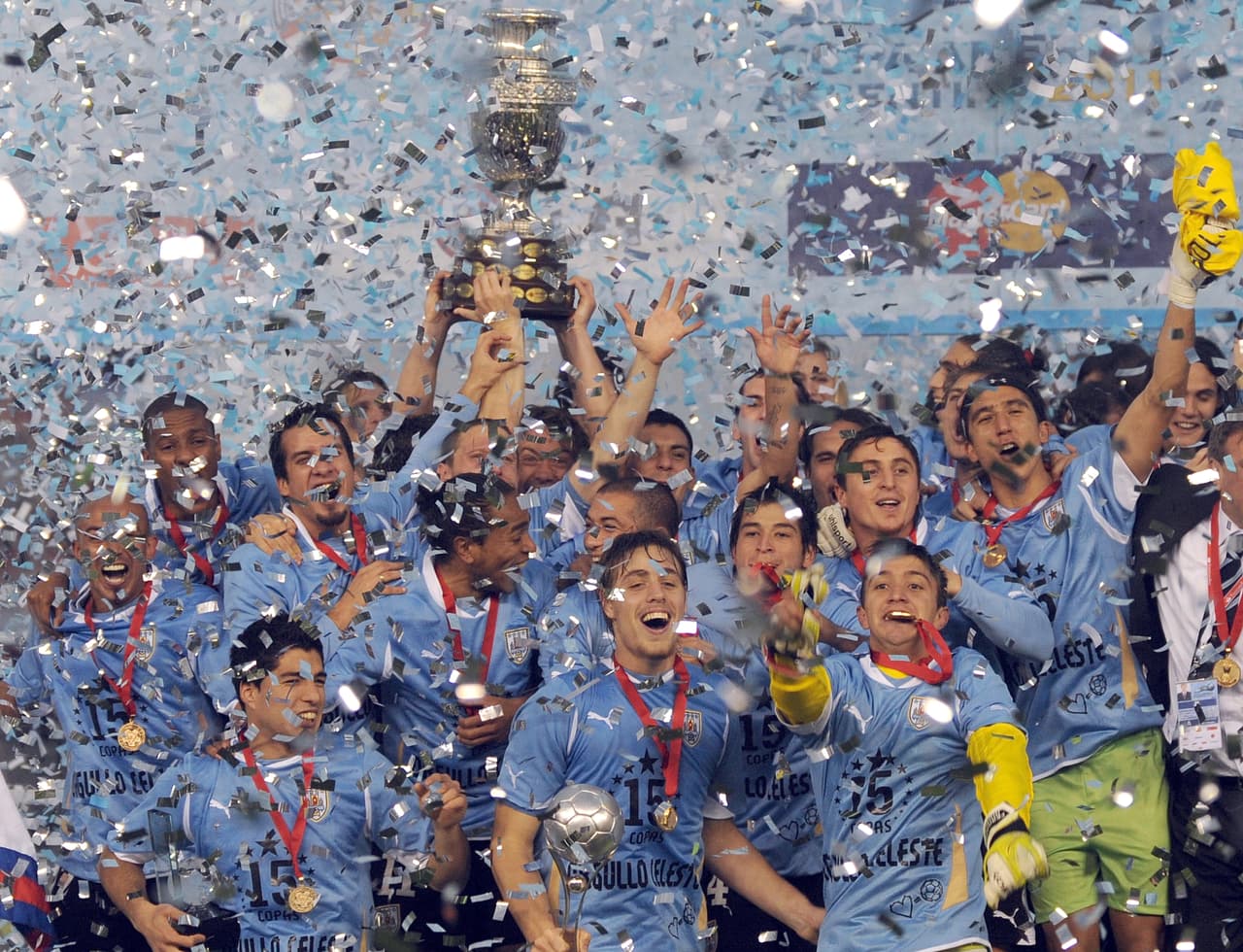 Uruguayan defender Diego Lugano (C) raises the trophy and celebrates with teammates at the end of the 2011 Copa America football tournament final against Paraguay held at the Monumental stadium in Buenos Aires, on July 24, 2011. Uruguay won 3-0 and became champion of the 2011 Copa America. AFP PHOTO / ANTONIO SCORZA (Photo credit should read ANTONIO SCORZA/AFP/Getty Images)