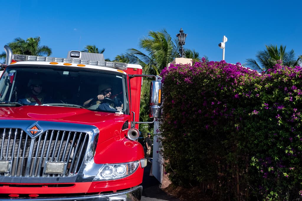 Una ambulancia con personal de primeros auxilios con cascos y chalecos antibalas de kevlar se prepara para unirse a la caravana de vehículos que sale del club Mar-a-Lago del presidente Donald Trump, el lunes 22 de diciembre de 2025.