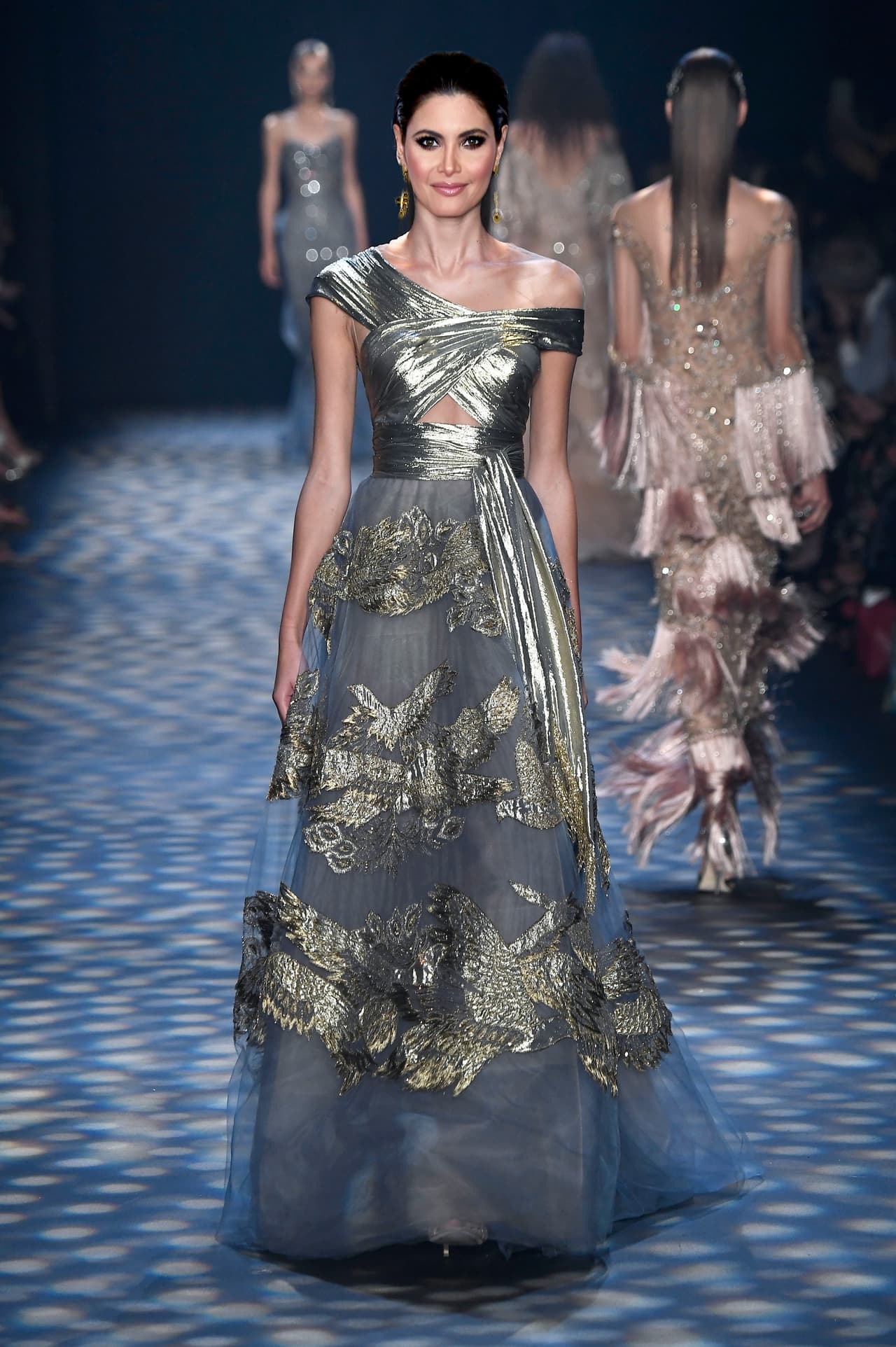 Pero si antes que apostar por la opulenta sensualidad de Versace, Chiquinquirá Delgado quisiera lucir clásica y romántica, podría apostar por un vestido de corte princesa y corpiño drapeado metalizado como el que presentó Marchesa en su reciente pasarela en Nueva York.