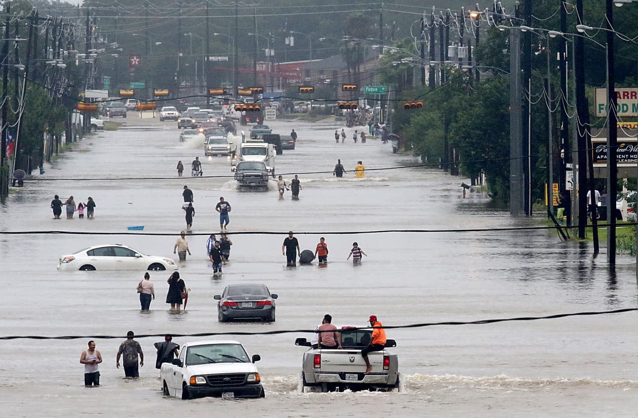Residentes atraviesan un rio que se formó sobre la calle Telephone Rd. Muchas calles de Houston se encuentran totalmente anegadas. Al menos 1,000 personas ya han sido rescatadas de las aguas.
<br>