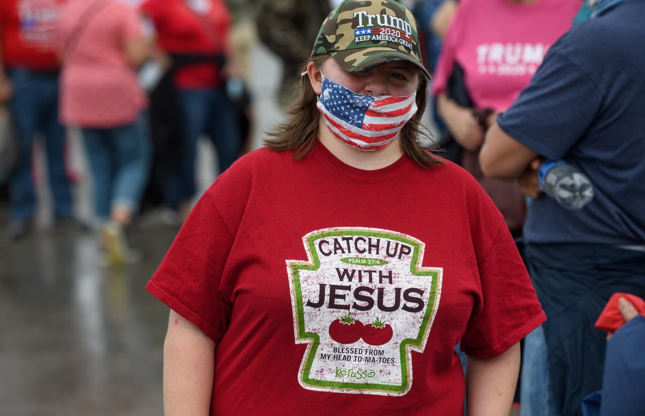 Mikayla McDonald de Vandergrift, Pennsylvania, usa una peculiar playera mientras espera con otros simpatizantes de Trump para abordar un autobús de enlace antes del evento de campaña.