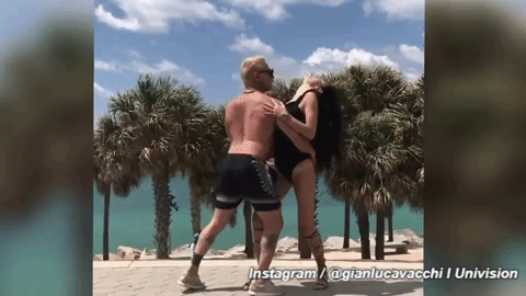 Pegadito y con la mano en la cintura de su compañera de baile.