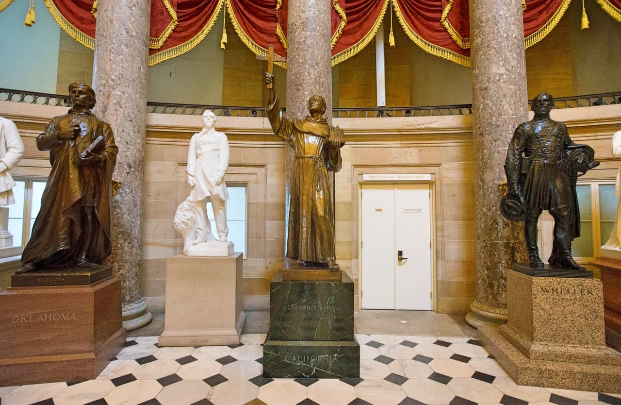 Estatua del misionero español Junípero Serra (al centro), en un salón de la Cámara de Representantes en Washington DC, quien es una de varias figuras asociadas con la conquista española que están siendo cuestionadas por sectores que opinan que no debería haber monumentos ni ceremonias de homenaje a personas que trataron con crueldad a los indígenas y al medio ambiente.