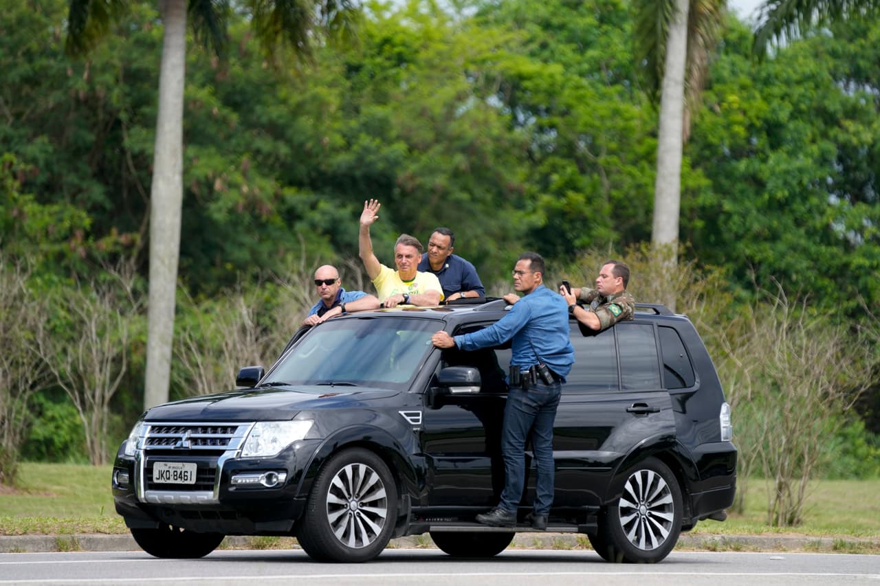 Jair Bolsonaro saluda desde un automóvil en la imagen. La administración de Bolsonaro se ha caracterizado por un discurso incendiario, su puesta a prueba de las instituciones democráticas, su manejo ampliamente criticado de la pandemia de COVID-19 y la peor deforestación en la selva amazónica en 15 años.