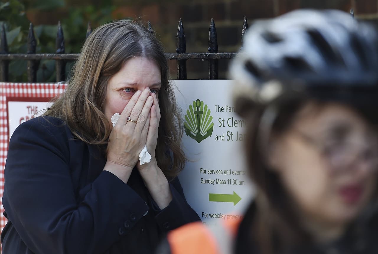 Una mujer llora mientras los bomberos trabajan en las labores de extinción de un incendio declarado en la Torre Grenfell en Lancaster West Estate en Londres.