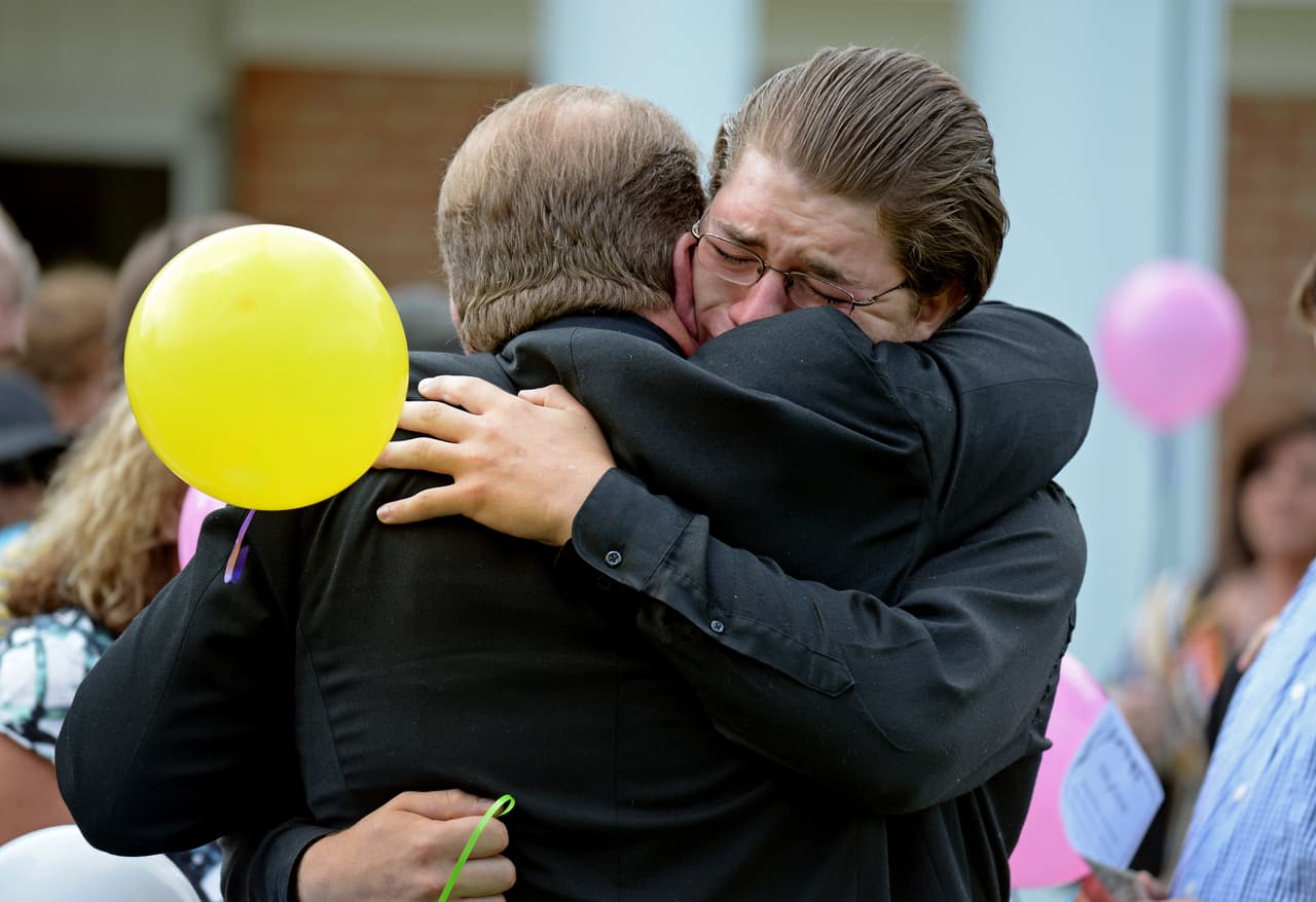 Timothy Jones, Sr. (izquierda), abraza a su hijo Travis Jones durante un servicio conmemorativo en Amory, Mississippi, el viernes 12 de septiembre de 2014. La policía afirma que Timothy Ray Jones Jr., de 32 años, asesinó a sus tres hijos y dos hijas, envolvió sus cuerpos en bolsas de basura individuales y condujo durante días por varios estados con sus cuerpos en descomposición antes de abandonarlos en una colina rural de Alabama. Los niños fueron recordados en la Iglesia de Cristo de Amory. Durante el programa se mostró una foto de cada niño sonriendo y se describió lo que les gustaba hacer. (Foto AP/Thomas Graning)
