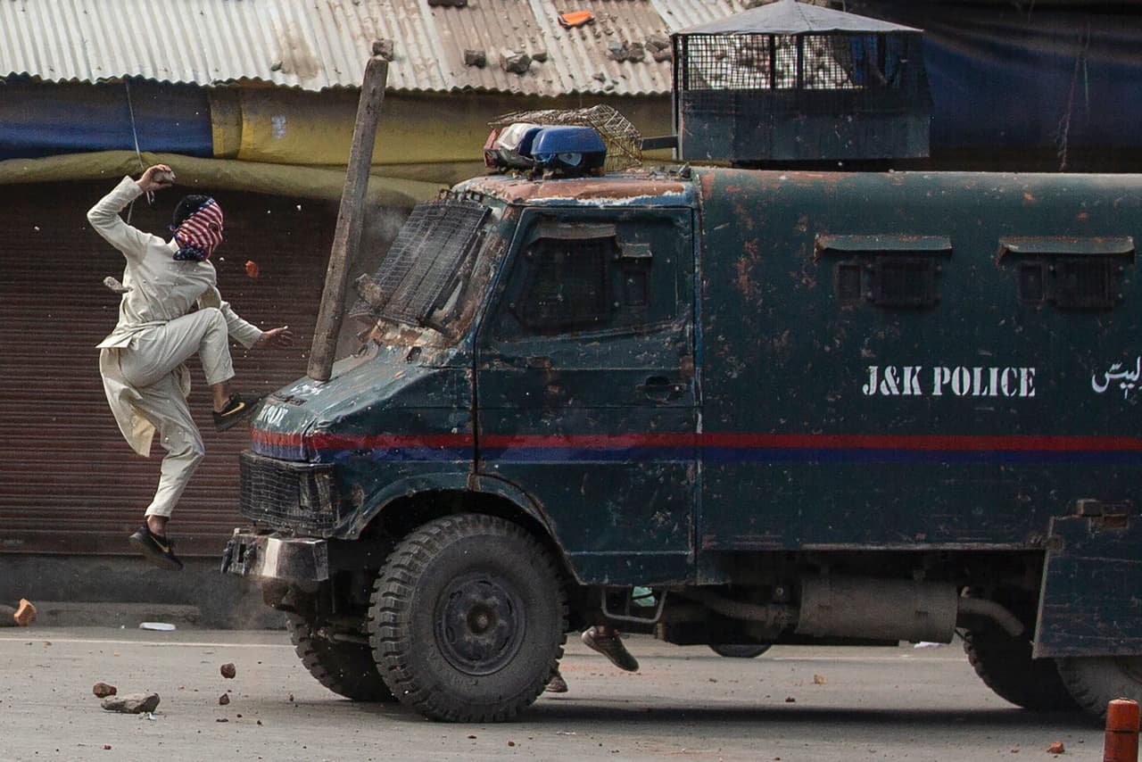 Un manifestante enmascarado de Cachemira salta sobre un vehículo blindado de la policía india durante una protesta en Srinagar, el 31 de mayo de 2019. La región de Cachemira está ubicada entre India y Pakistán y se ha mantenido una disputa entre estos dos países por ese territorio desde hace más de 7 décadas.