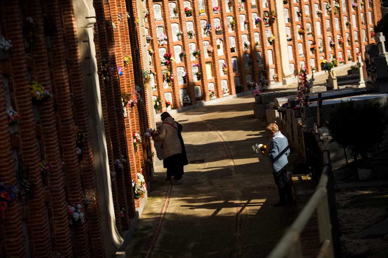 <b>España.</b> Madrileños llevan flores a sus familiares en el cementerio de la Almudena, en Madrid.