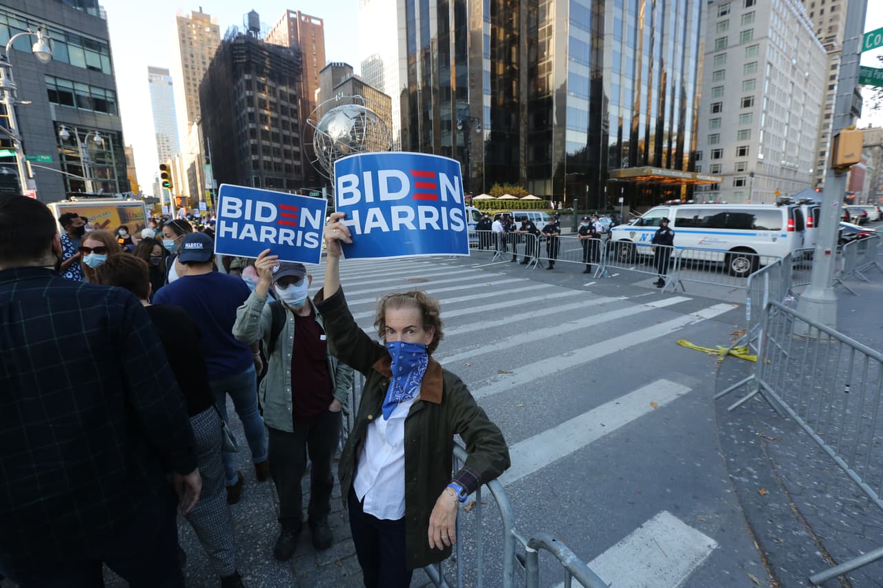 Mientras manifestante celebran la victoria de Biden, miembros del NYPD custodian el perimetro del Hotel Trump International.