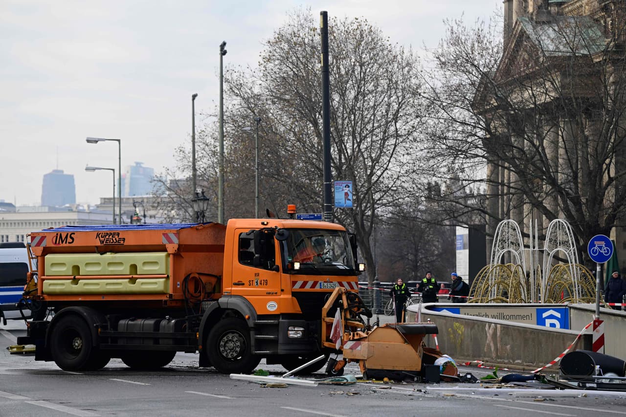 Un vehículo del departamento de limpieza de la ciudad limpia la calle de escombros frente al hotel Radisson Blu.