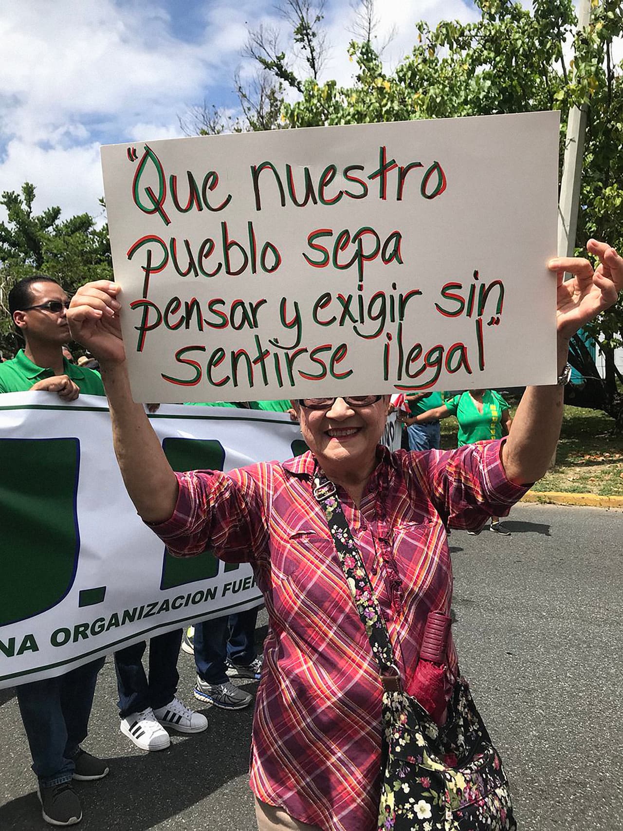 <b>"Que nuestro pueblo sepa pensar y exigir sin sentirse ilegal",</b> se lee en la pancarta de esta mujer que también marchó este martes. (Foto del Twitter de la alcaldesa de San Juan, Carmen Yulín Cruz)