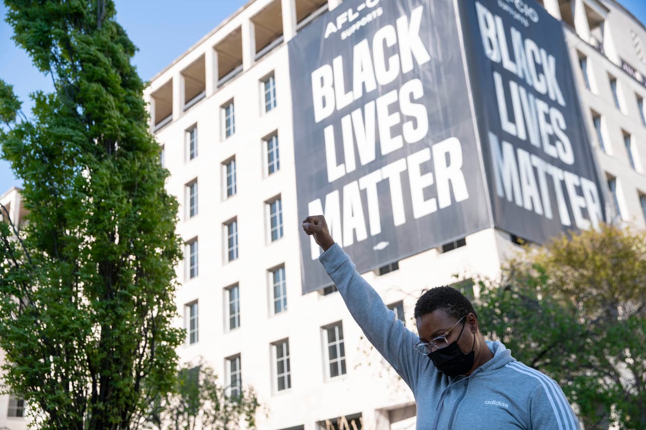 Un hombre con el puño en alto en la plaza Black Lives Matter de Washington DC, poco después de escuchar 
<b><a href="https://www.univision.com/noticias/estados-unidos/veredicto-juicio-derek-chauvin-muerte-george-floyd" target="_blank">el veredicto en el juicio al expolicía Derek Chauvin por la muerte de George Floyd</a></b>. Chauvin 
<a href="https://www.univision.com/temas/derek-chauvin-veredicto">fue declarado culpable</a> de tres cargos de homicidio y asesinato, a casi un año del fallecimiento del afroestadounidense el pasado 25 de mayo.