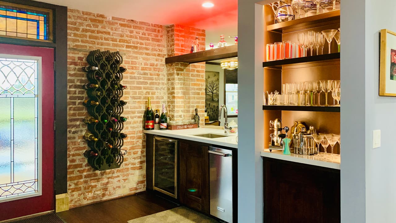 La pared de ladrillo original quedó intacta en esta área del bar a lado de la cocina.