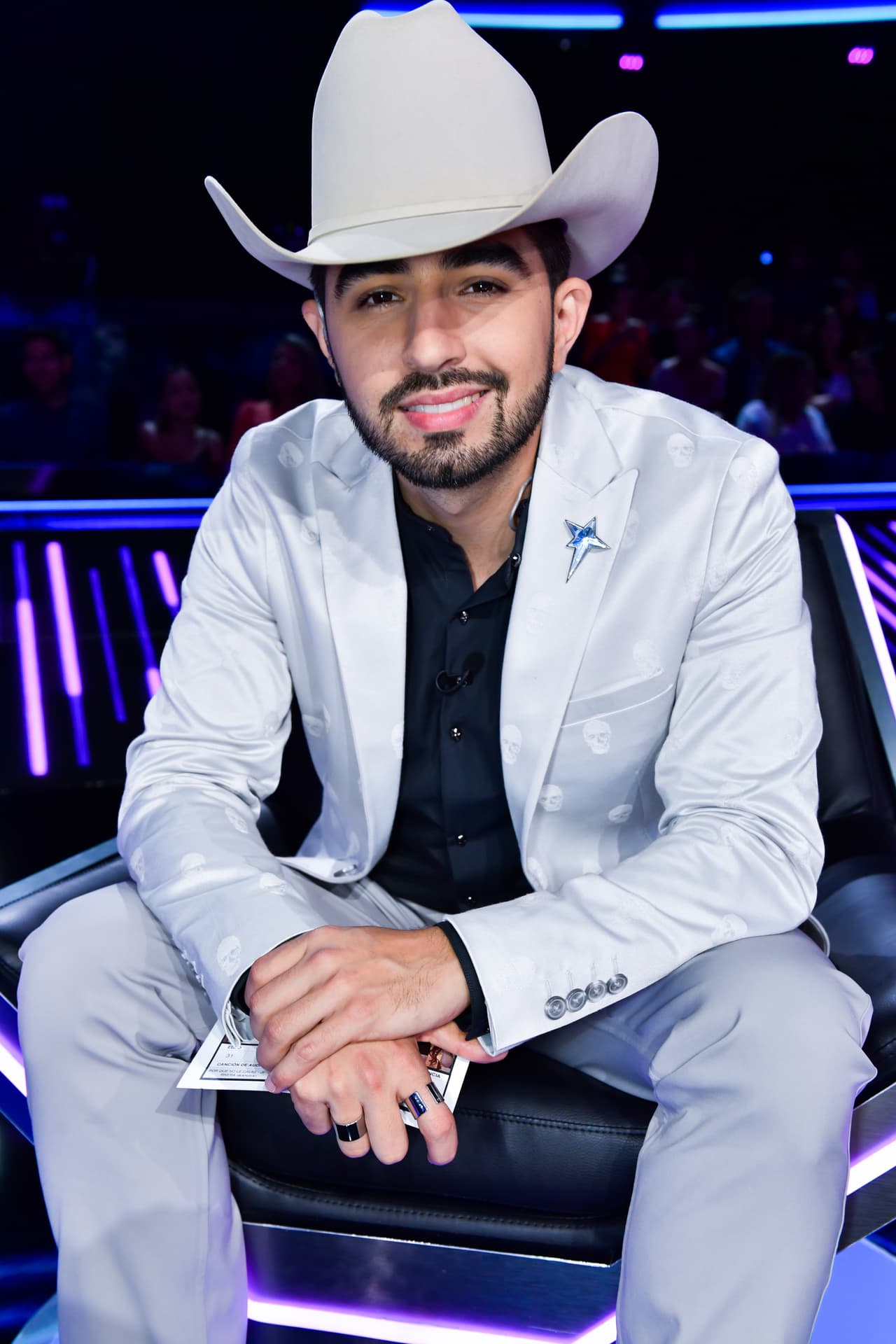 El saco con terminados brillantes vino muy bien con los accesorios que seleccionó para esta ocasión. En el saco colocó un pin de Thierry Mugler y los anillos son de The Astorga Project.