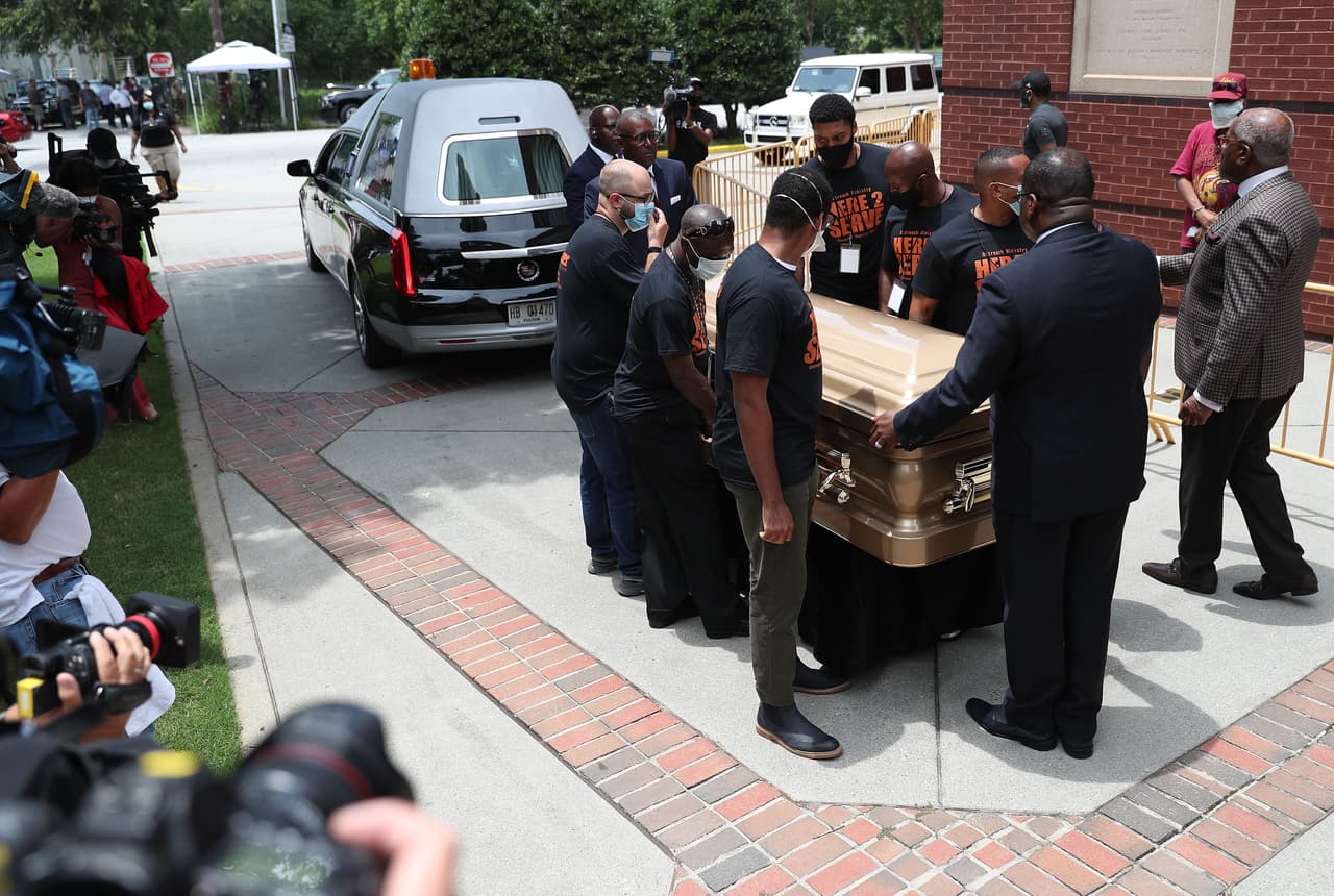 Un grupo de hombres cargan féretros con los restos de Rayshard Brooks para ingresar a la Iglesia Bautista Ebenezer. Brooks fue asesinado el 12 de junio por un oficial de policía de Atlanta después de una lucha durante una prueba de sobriedad en el estacionamiento de un restaurante de Wendy's.