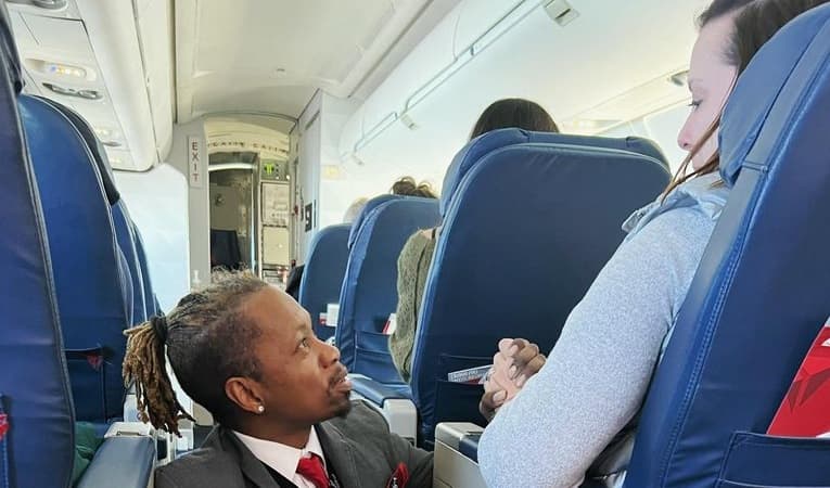 Asistente de vuelo consuela a mujer durante turbulencia, la imagen se hace viral