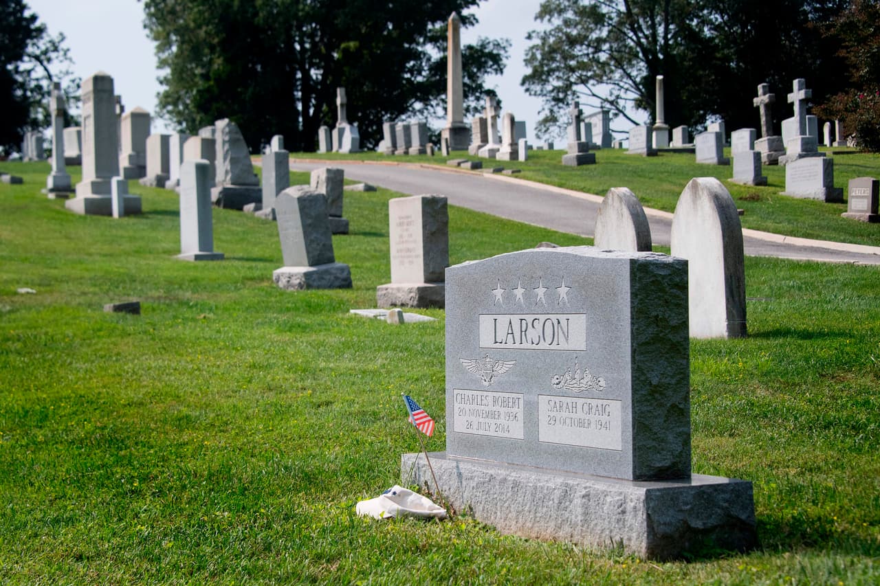 A flag is placed at the base of the tombstone of US Navy admiral Charles "Chuck" Larson at the US Naval Academy in Annapolis, Maryland, on August 24, 2018, near where US Senator John McCain will be laid to rest next. - McCain let it be known in his memoir published in May 2019, "The Restless Wave," that he wished to be laid to rest in Maryland, near his old Navy pal, Chuck Larson. (Photo by Jim WATSON / AFP) (Photo credit should read JIM WATSON/AFP/Getty Images)