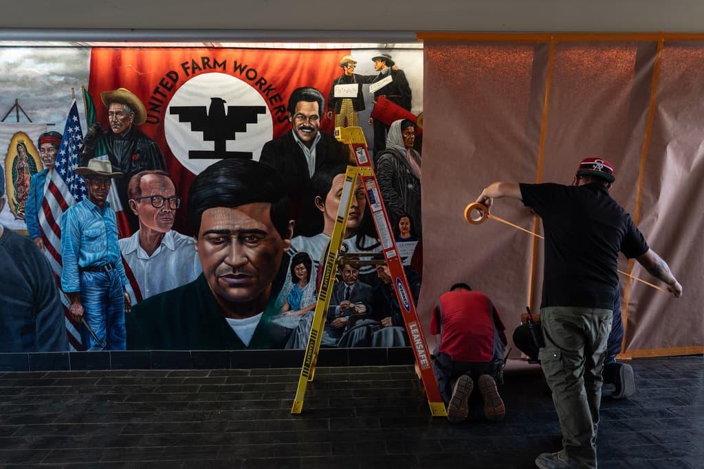 Unos trabajadores cubren un mural hecho por Emigdio Vásquez en el que aparecen César Chávez y otras figuras en el Santa Ana College de Santa Ana, California, el jueves 19 de marzo de 2026.