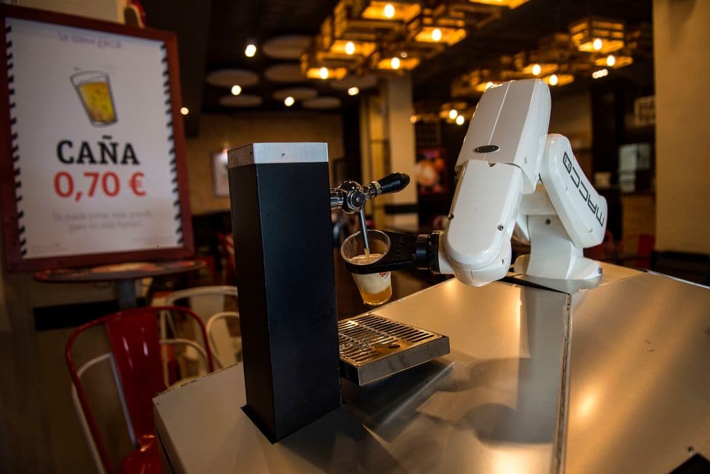 El brazo toma el vaso de un dispensador, lo coloca medio inclinado bajo el tirador de cerveza y lo llena hasta el borde. Entonces, deposita la cerveza, con una cantidad justa de espuma, encima la barra, en donde el cliente puede recogerla.