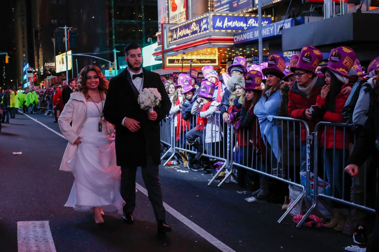 Una novia y su esposo pasean por Times Square para recibir el Año Nuevo.