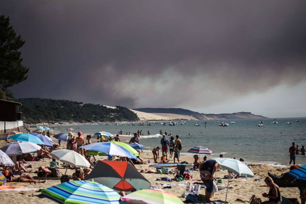 Así se veía esta semana una nube de humo de uno de los incendios desde la playa 'Pyla sur mer', en el suroeste del país, llena de bañistas por el calor.