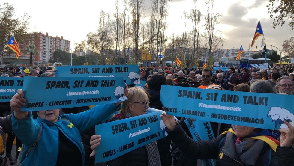 Los grupos de Tsunami Democàtic ya se reunen para protestar camino al Camp Nou. El movimiento independentista cuenta con 100 mil cartulinas con el lema 'Spain, sit and talk', mismas que reparten a la gente para ser mostradas después del himno del Barça.