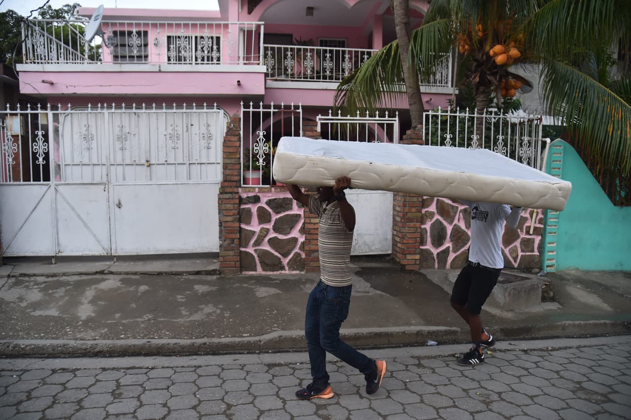 Según Charles, el gobierno enfrenta dos problemas: la atención a los heridos y el manejo del miedo. Dos jóvenes trasladan un colchón en una calle de Port-de-Paix.