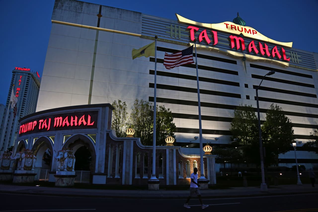 En la entrada al Trump Taj Mahal por la Pacific Avenue en Atlantic City, Nueva Jersey, ondean las banderas de Estados Unidos, de Nueva Jersey y del imperio Trump. Las calles aledañas por lo general están solas, sin transeúntes ni carros, 26 de mayo, 2016.