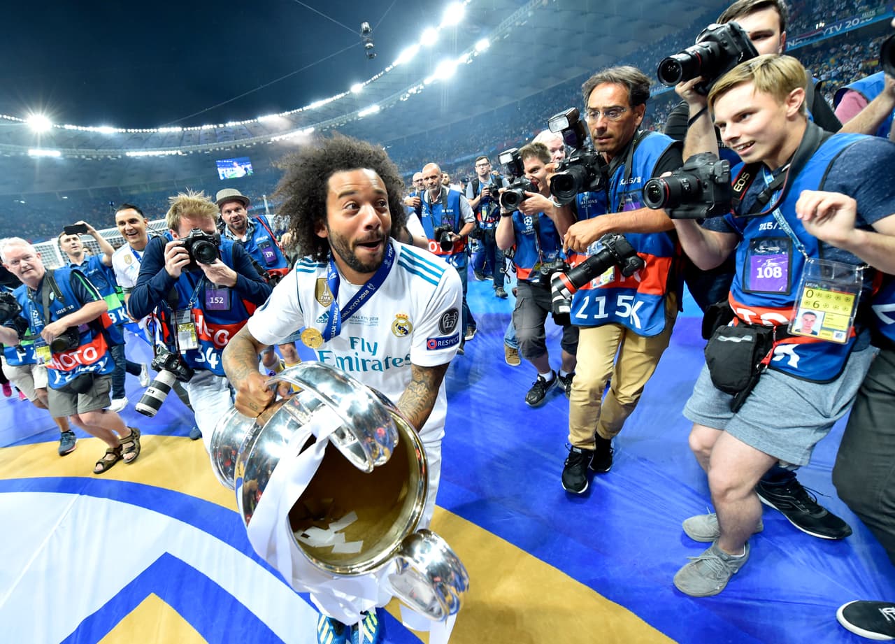Otro de los símbolos y referentes del Madrid, el lateral brasileño Marcelo, quien desde 2007 lleva adherida a su cuerpo la camiseta Merengue, festeja con 'la orejona' mientras huye de los fotógrafos.