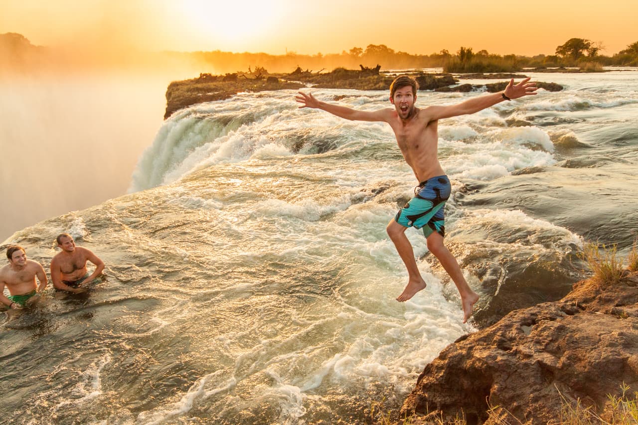 <b>Diciembre. La piscina del diablo, Cascadas Victoria, Zambia.</b>
<br>
<br>Por sí sola las Cataratas Victoria se podrían calificar como uno de los fenómenos naturales más hermosos del mundo. Aproximadamente una milla de ancho con una caída de 360 pies, es la cortina de agua más grande del planeta.
<br>
<br>Pero lo que tiene en su cima es aún más inusual: un hoyo natural en el borde de la caída de agua con una barrera de roca
<a href="https://www.zambiatourism.com/"><u>que permite nadar con seguridad hasta el borde de la cascada</u></a>.