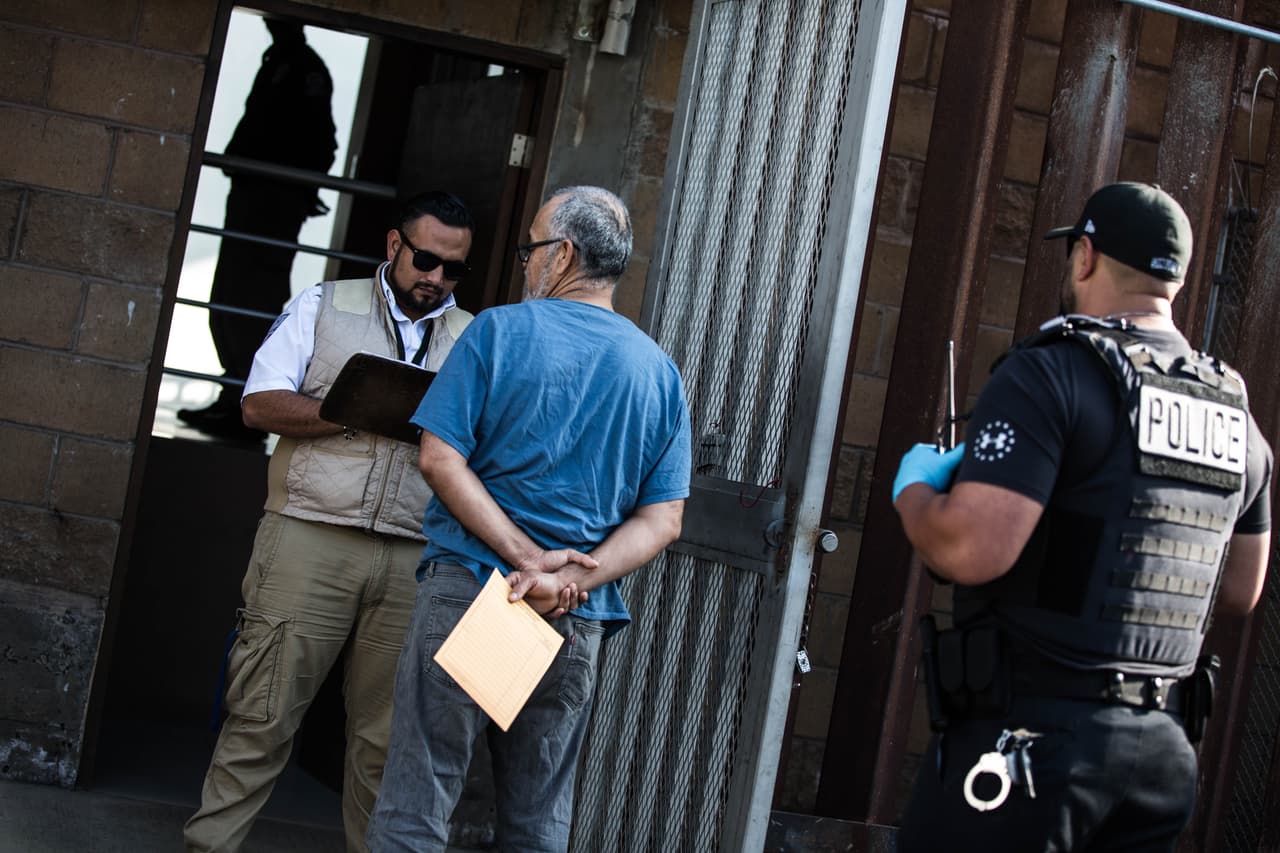 El agente federal de migración de México, vestido de marrón, los recibe y les hace varias preguntas a los inmigrantes antes de dejarlos entrar al país: su nombre, edad, estado de salud, si son mexicanos y de qué parte del país. Anota las respuestas en una carpeta. Almudena Toral/Univision Digital