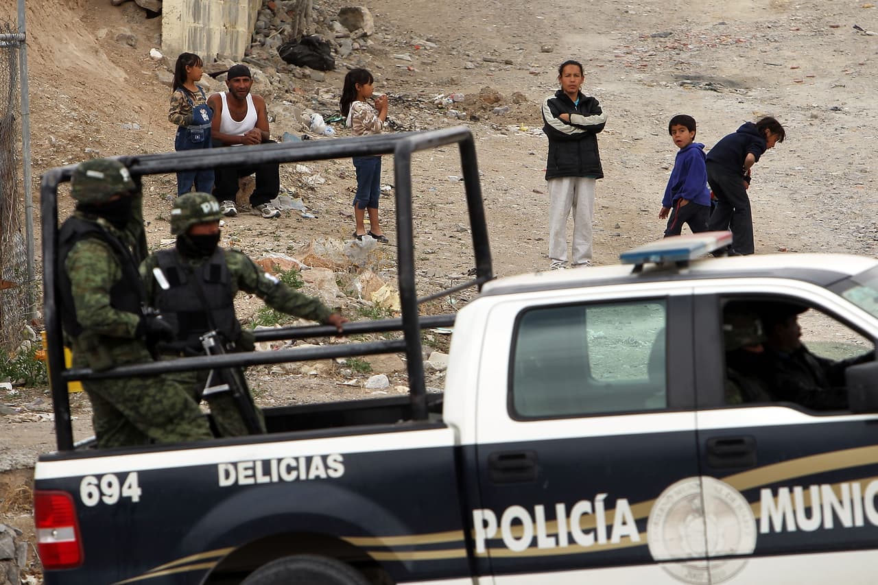 Pobladores de Chihuahua miran la escena de un crimen mientras policías municipales resguardan el lugar. (Imagen de archivo)