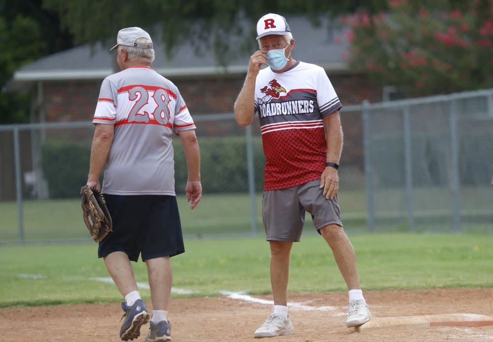 Rick McAll, de 73 años, usa una máscara 
<b>mientras se para en la primera base después de golpear un sencillo durante un juego de softbol para adultos mayores en Richardson, <a href="https://www.univision.com/temas/texas">Texas</a></b>, el 21 de julio de 2020.