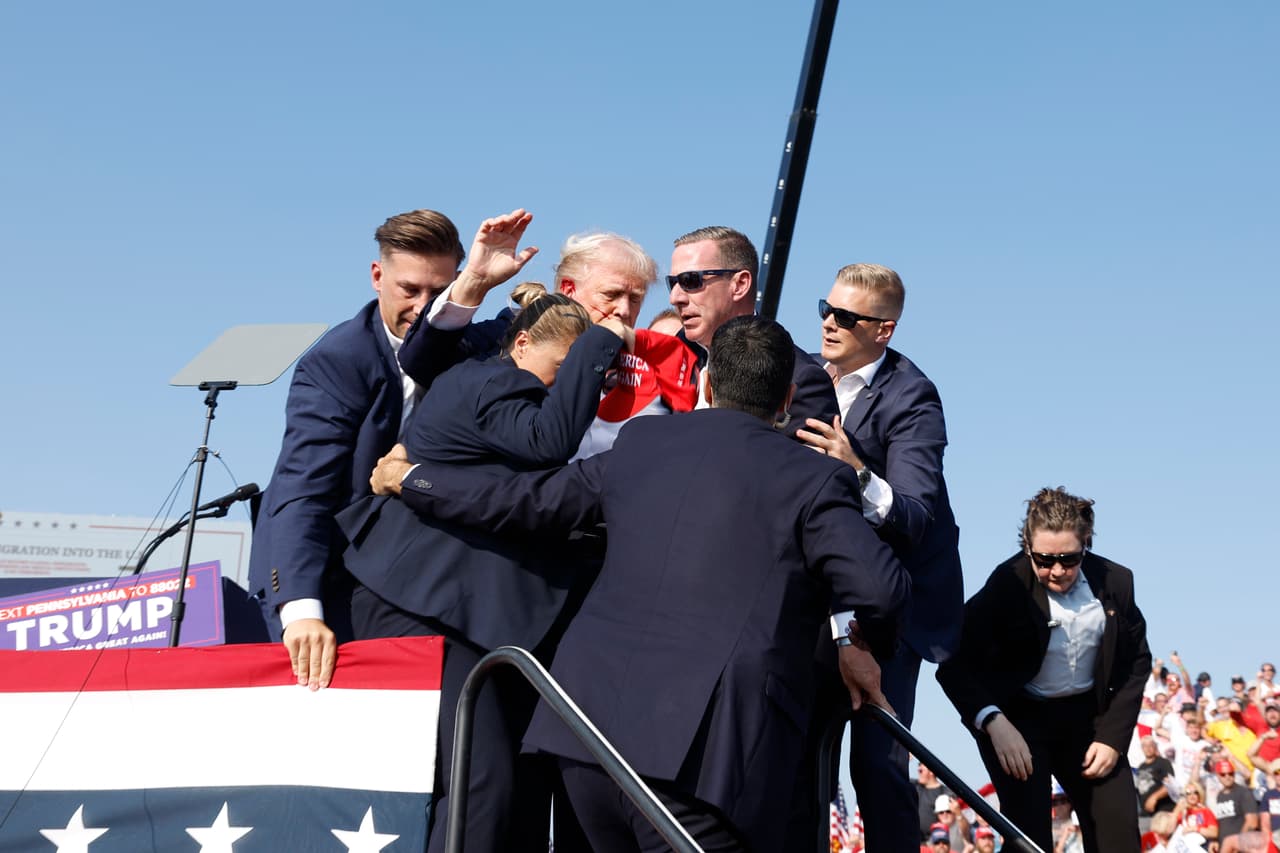 Así lo evacuaban del escenario. Cuando ocurrían los disparos, se podía escuchar a alguien decir cerca del micrófono en el atril de Trump: "
<b>¡Al suelo, al suelo, al suelo, al suelo!" </b>mientras los agentes abordaban al expresidente. 
<br>