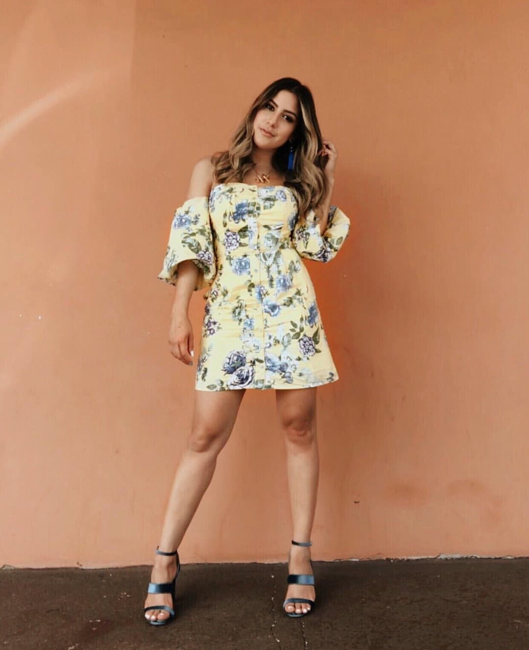 Jessy Rodríguez posó con un vestido corto en silueta línea 'A' color amarillo pálido y con detalles florales en la gama de los azules. Nos encantaron las mangas abultadas y los hombros al descubierto. La presentadora de Despierta América agregó en los zapatos el acabado metálico.