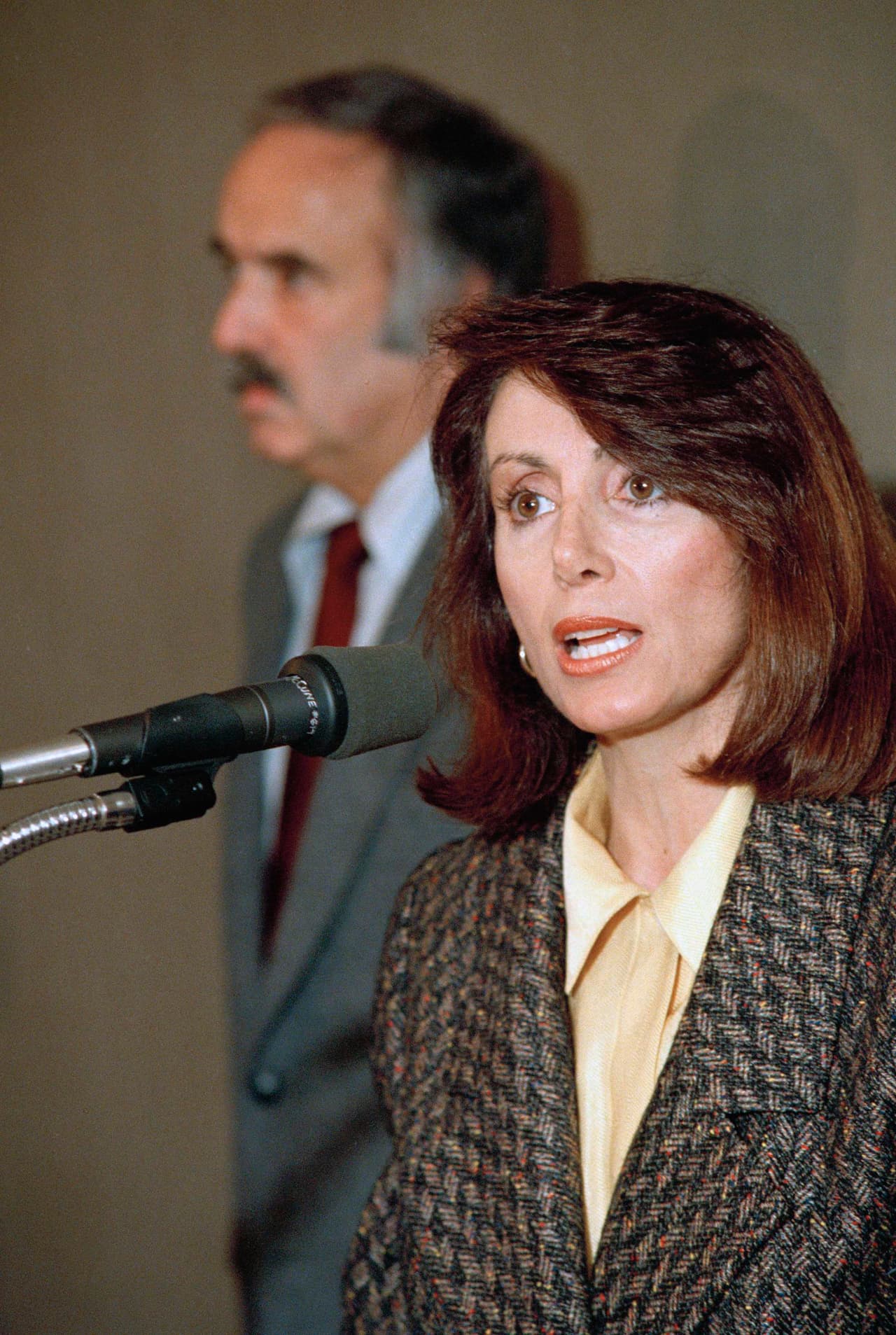 Elegida por primera vez en 1987, Pelosi ha sido una figura fundamental en la política estadounidense, ridiculizada durante mucho tiempo por los republicanos como una liberal de San Francisco mientras ascendía constantemente como una legisladora hábil y una potencia de recaudación de fondos. Sus propios colegas demócratas han apreciado intermitentemente, pero también han temido, su poderosa marca de liderazgo.
<br>
<br>En la foto, la expresidenta del Partido Demócrata del Estado de California, Nancy Pelosi, habla durante una conferencia de prensa el jueves 12 de febrero de 1987 por la mañana, donde anunció formalmente su candidatura para el quinto escaño del distrito del Congreso que quedó vacante por la muerte de la representante Sala Burton. Detrás de Pelosi se encuentra el exrepresentante John Burton. Cuñado de Sala Burton y presidente de campaña de Pelosi.