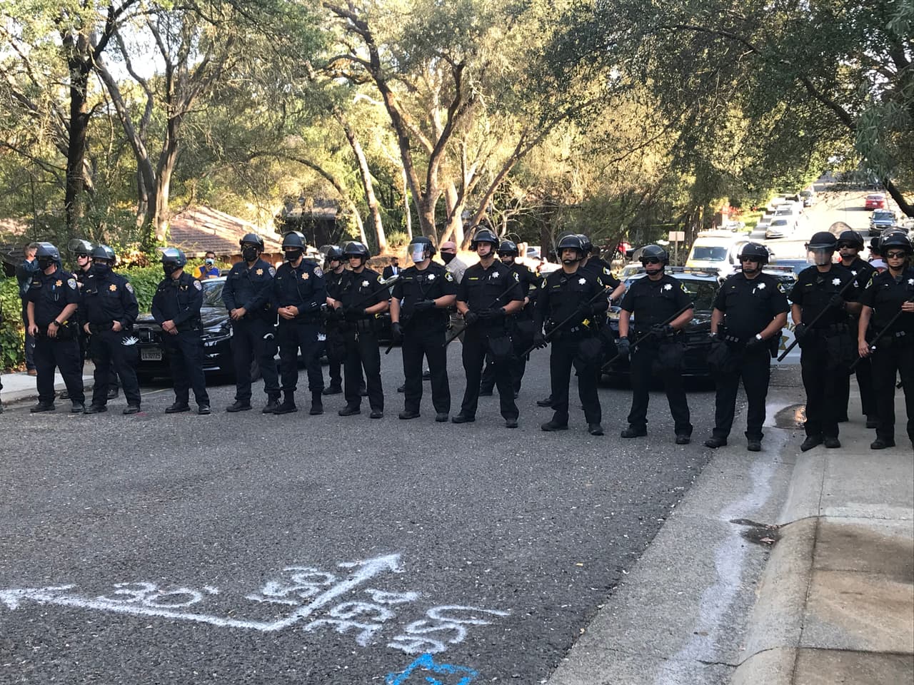 Después de alrededor de dos horas de protesta, oficiales removieron a los manifestantes que se habían atado con cadenas a la puerta de la casa del gobernador.