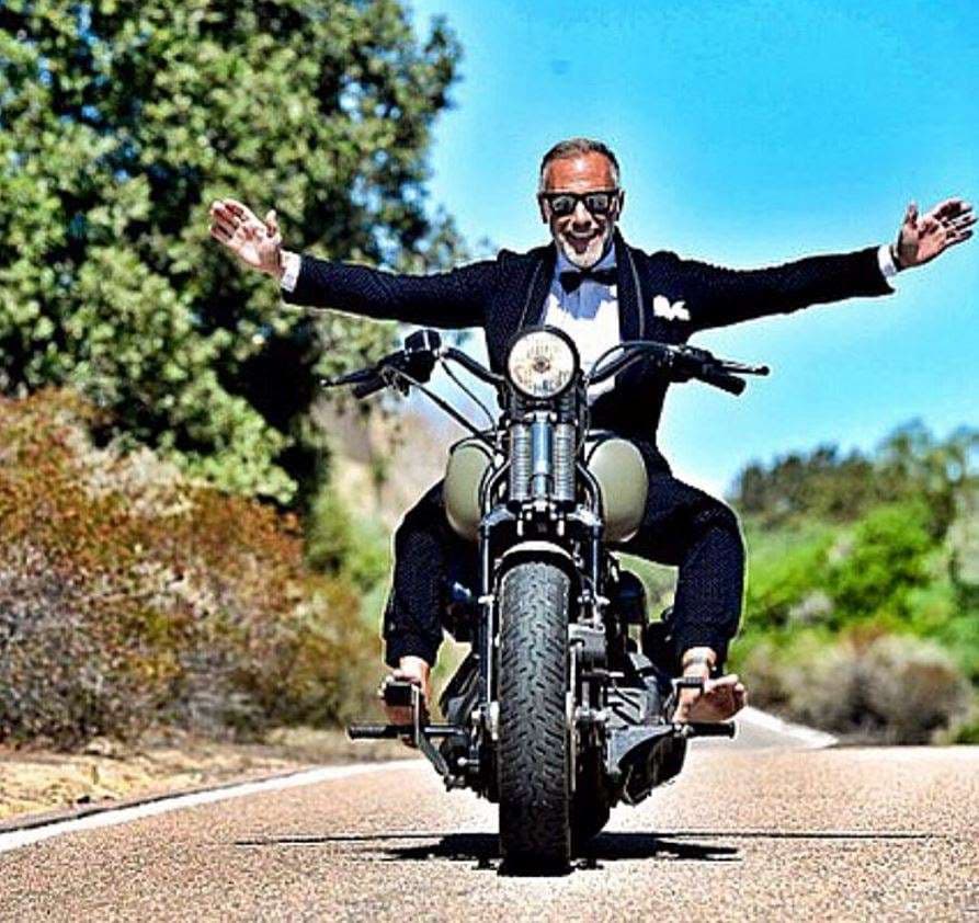 Sin casco, sin manos... así posa para sus fans y pone en riesgo su vida por una foto. Ojo al detalle de los pies. Va con un esmoquin, pero sin zapatos.