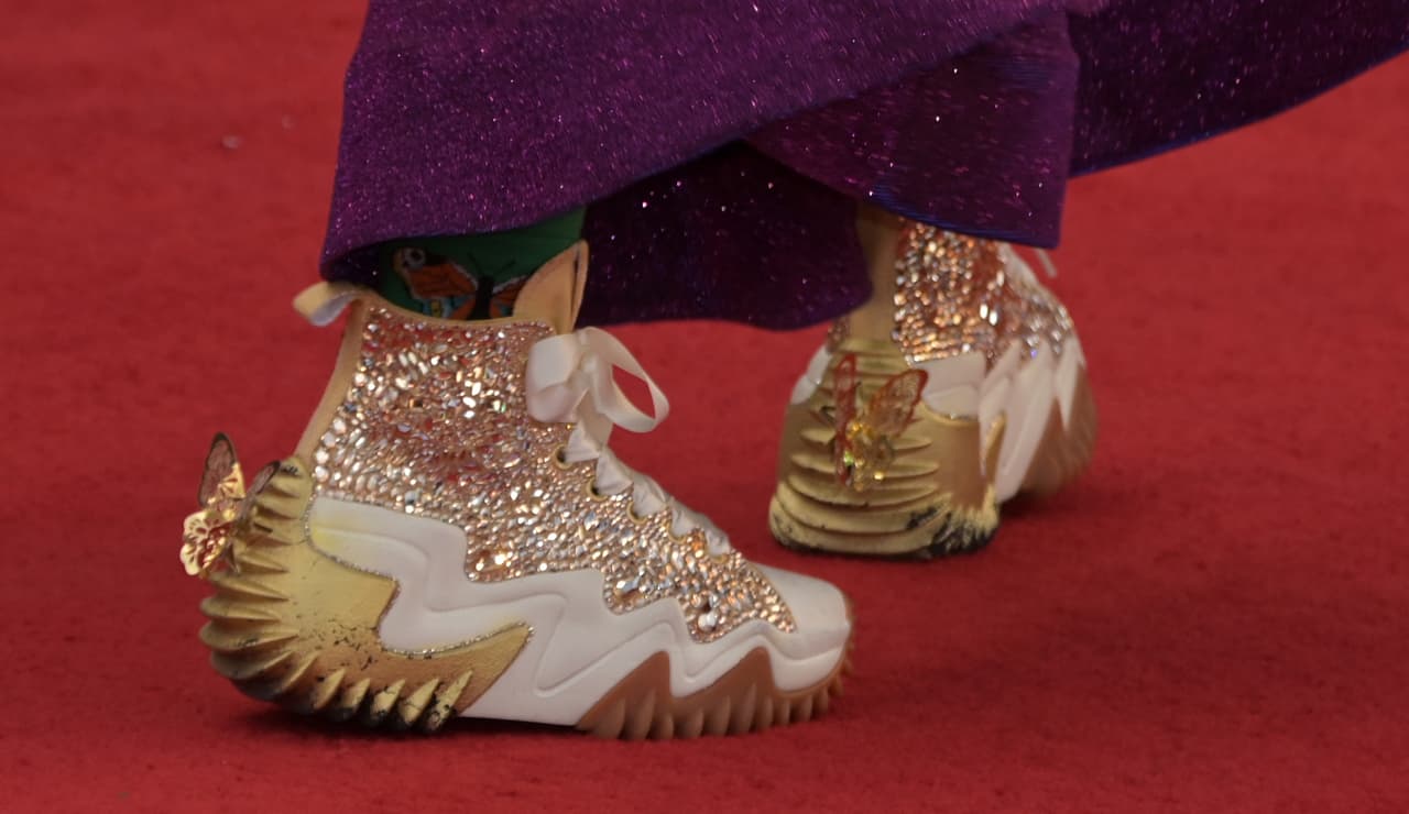 Sus sneakers presumieron brillos y mariposas que hicieron match con la enorme mariposa dorada de su crop-top.