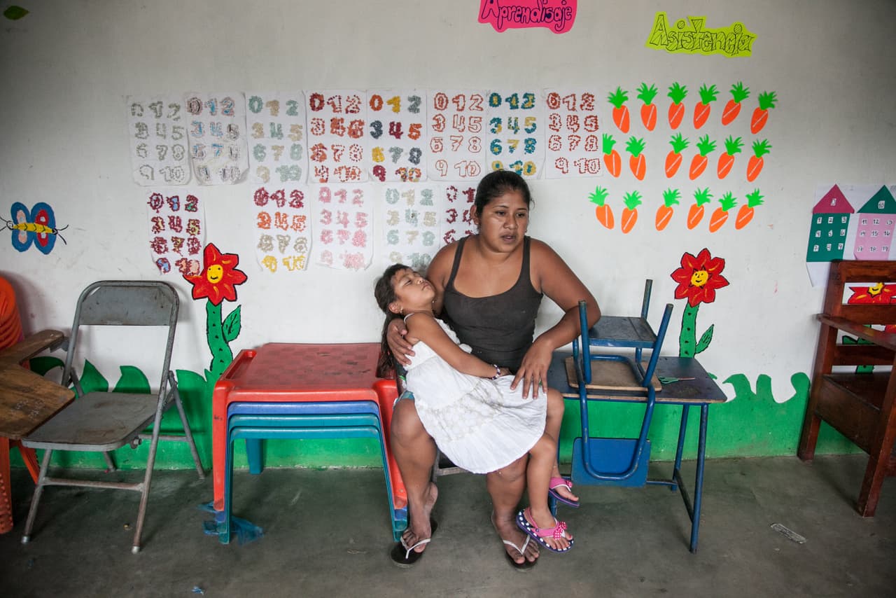 Alma Lucerito Chávez sostiene en brazos a su hija que se ha quedado dormida en medio de su fiesta de bienvenida en el colegio. "Yo siento mucho coraje porque cómo es posible que le hicieron esto", lamenta. "Lo que yo estoy viviendo con mi hija a los demás no les gustaría eso de sus hijos porque los niños ya no vienen igual. Vienen espantados".