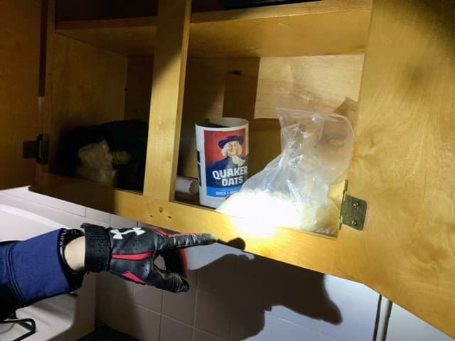 La policía se puso en contacto con la DEA después de recibir información sobre una actividad inusual en el apartamento, que estaba vacío. Tras revisar el video de seguridad del edificio, observaron a tres hombres entrando y saliendo, a veces llevando galones de acetona, así como suministros utilizados para convertir la metanfetamina en cristal, incluyendo una bandeja para hornear, una nevera azul grande y una olla grande para cocinar.