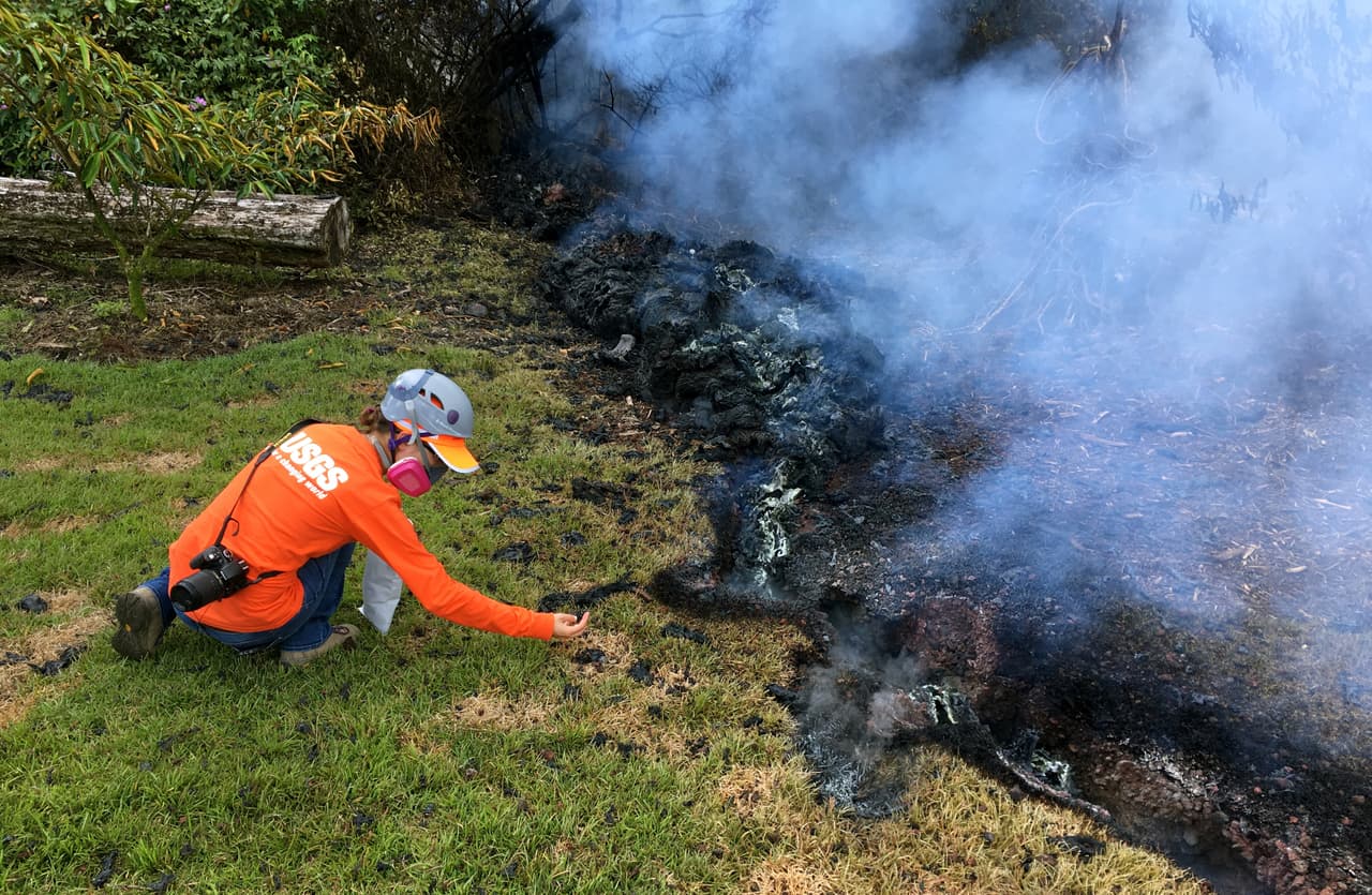 Geólogos del Observatorio Hawaiano de Volcanes recogen muestras de la lava que se desplaza lentamente por calles y jardines de Lailani Estates. El "extremadamente peligroso" dióxido de azufre sigue emanando del suelo en algunos lugares.