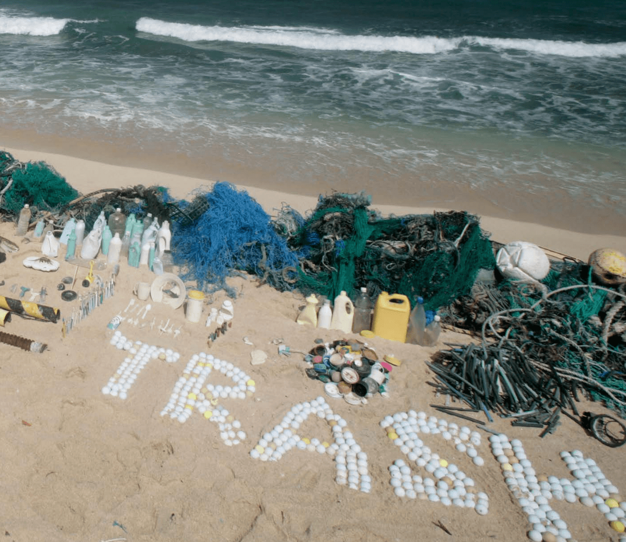 Residuos marinos clasificados por tipo, incluyendo la palabra “basura” hecha con pelotas de golf, en la playa de Kahuku, Hawaii 
<br>Foto: Alex Hofford / Greenpeace