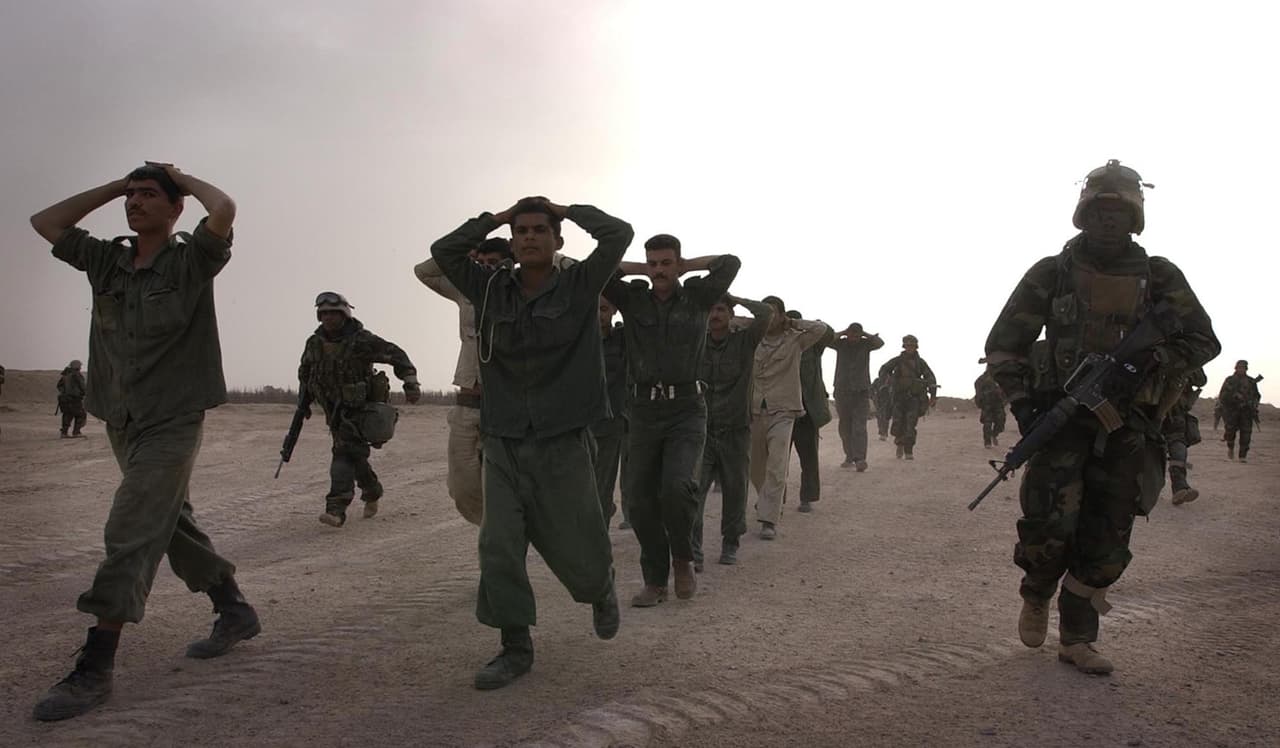 Irak recibió numerosas sanciones de la ONU despues de la invasión de Kuwait y se estableción una supervisión internacional para terminar con los programas de creación de armas de destrucción masiva. En la fotografía, soldados iraquíes capturados por el ejército de EEUU en Az Bayer, en la frontera con Kuwait el 21 de marzo de 2003.