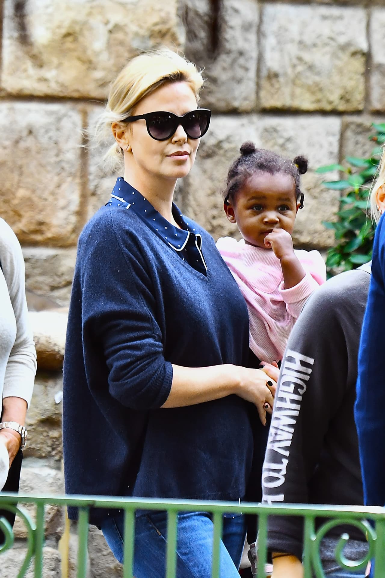 Charlize esperaba en las filas de las atracciones con su nena August en brazos.