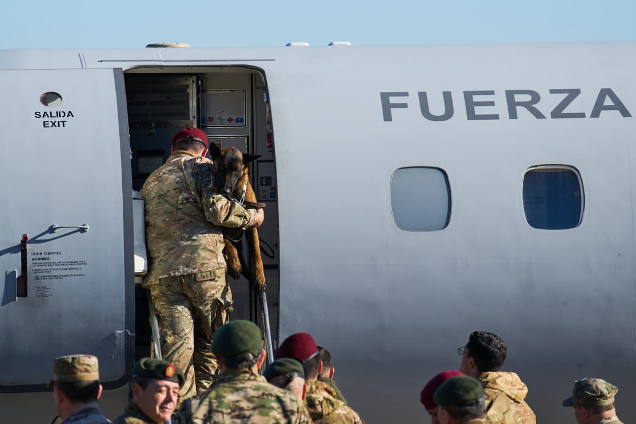 Un soldado sube a un avión con un perro de búsqueda y rescate antes de partir en una misión humanitaria para ayudar a las víctimas de los terremotos gemelos en Venezuela; Buenos Aires, Argentina, viernes 26 de junio de 2026.