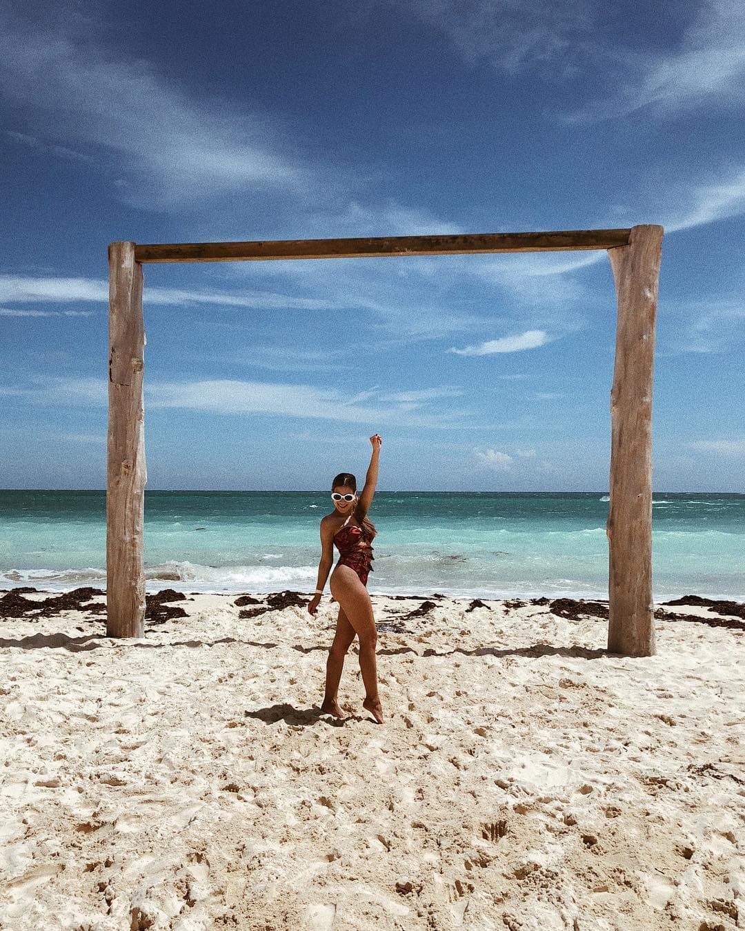 Jessi resaltó entre el azul del mar y la arena blanca con un traje de baño rojo con negro también 'strapless' y con detalles de nudos al frente.