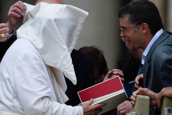 La ráfaga de viento que hace que la capa de Francisco se alborote parece causar la sonrisa de este peregrino.