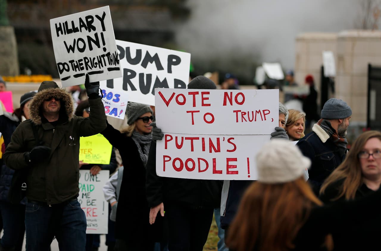 Ciudadanos estadounidenses se manifiestan afuera del Capitolio Estatal de Georgia, antes del encuentro de los dieciséis electores del estado, que emitirán sus votos este 19 de diciembre de 2016. El Colegio Electoral de EE.UU se reúne este lunes para certificar la victoria del republicano Donald Trump.